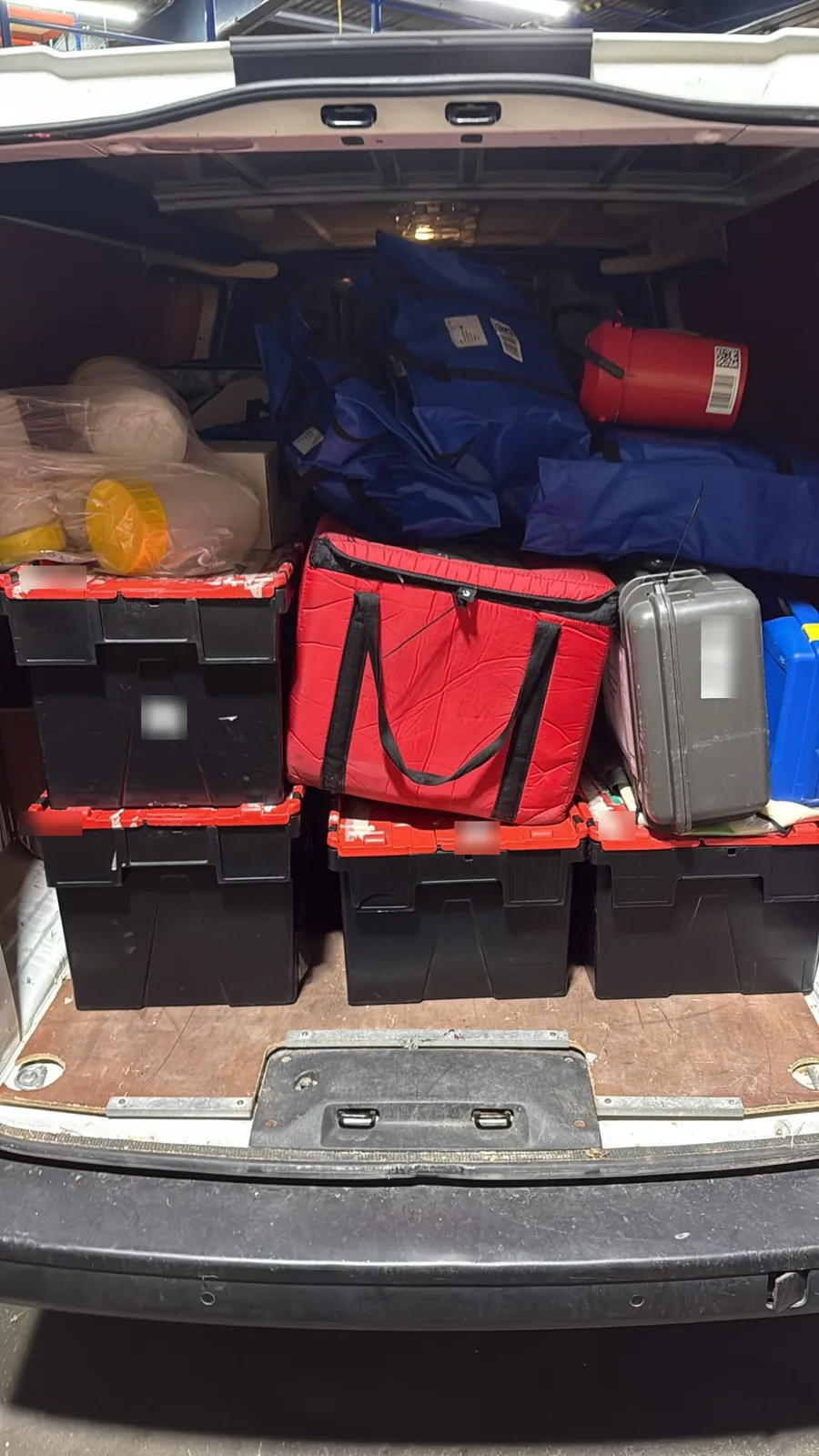 Red Eagle Logistics van loaded with stackable crates, a hard transport case and insulated bags on a night courier run